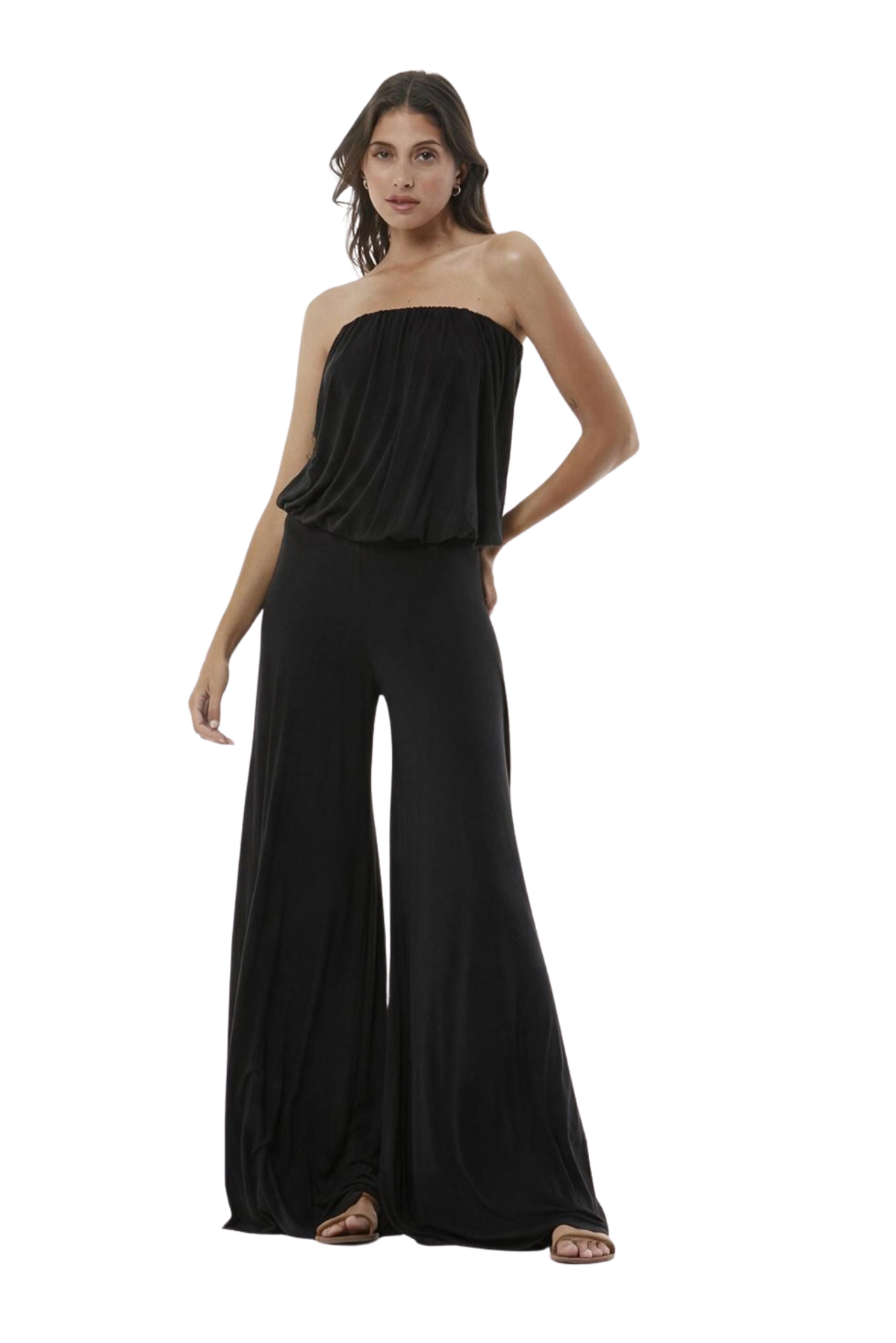 A woman modeling a black strapless jumpsuit, shown against a plain white studio background.