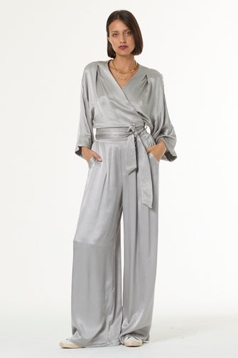 Woman wearing a silver top and bottom set on a white background
