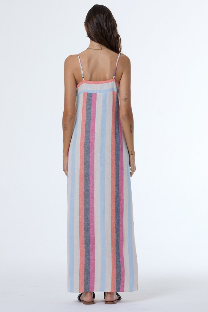 Woman wearing a long, striped dress with thin straps on a white background