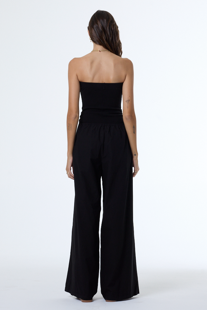Black strapless jumpsuit worn by a person on a white background