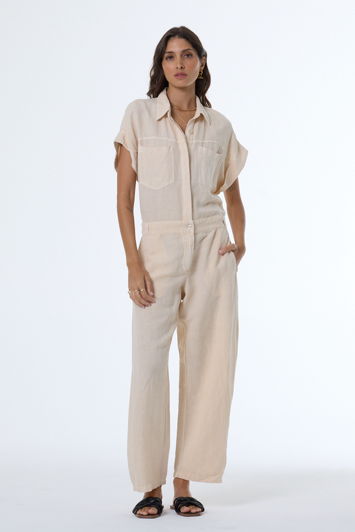 Woman wearing a beige jumpsuit on a white background