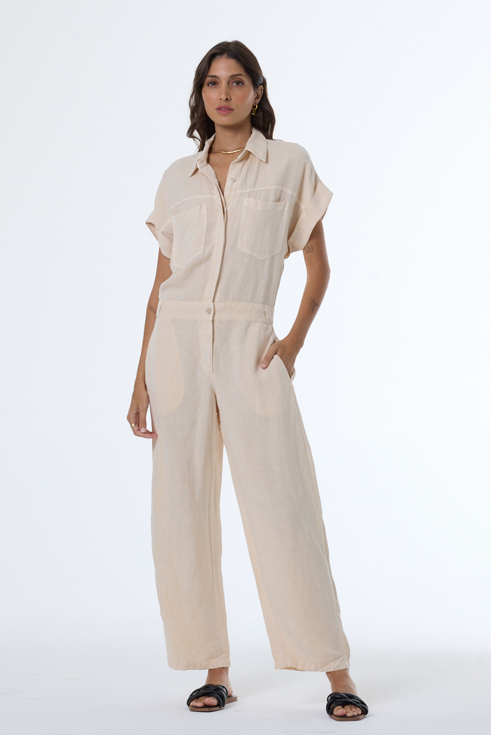 Woman wearing a beige jumpsuit on a white background