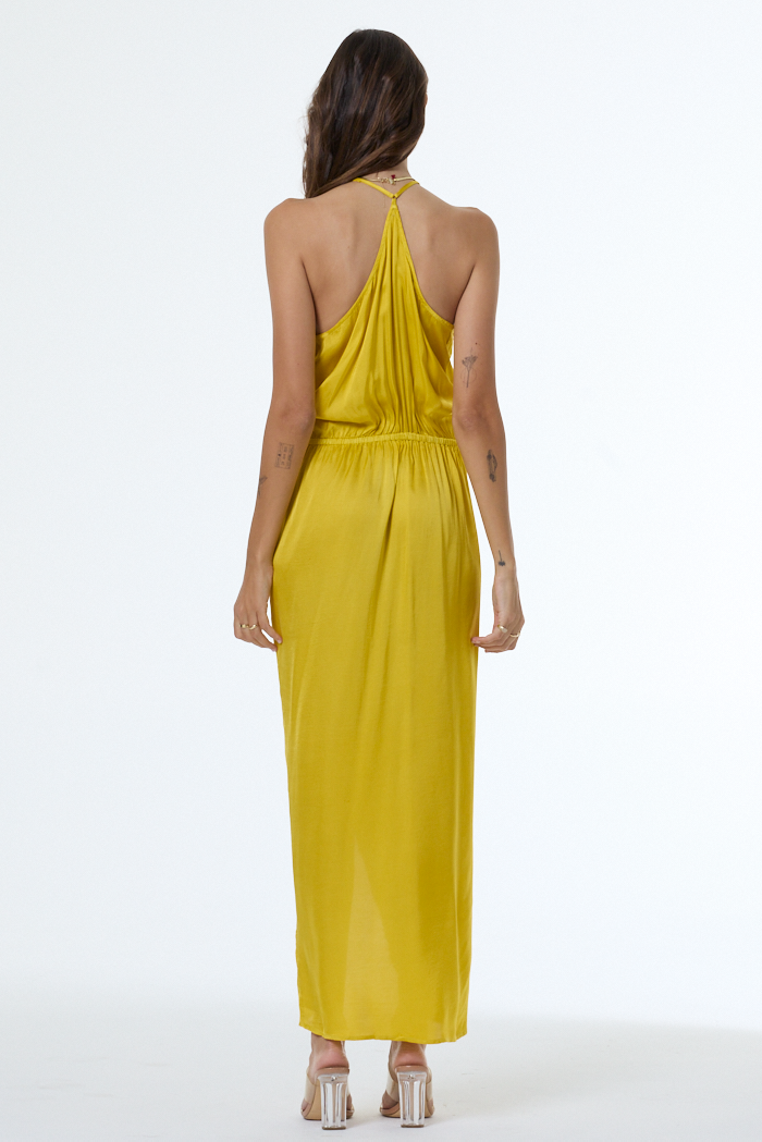 Woman wearing a yellow halter neck dress on a white background
