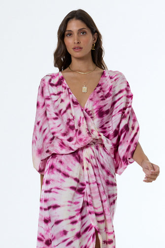Woman wearing a pink and white tie-dye dress on a white background