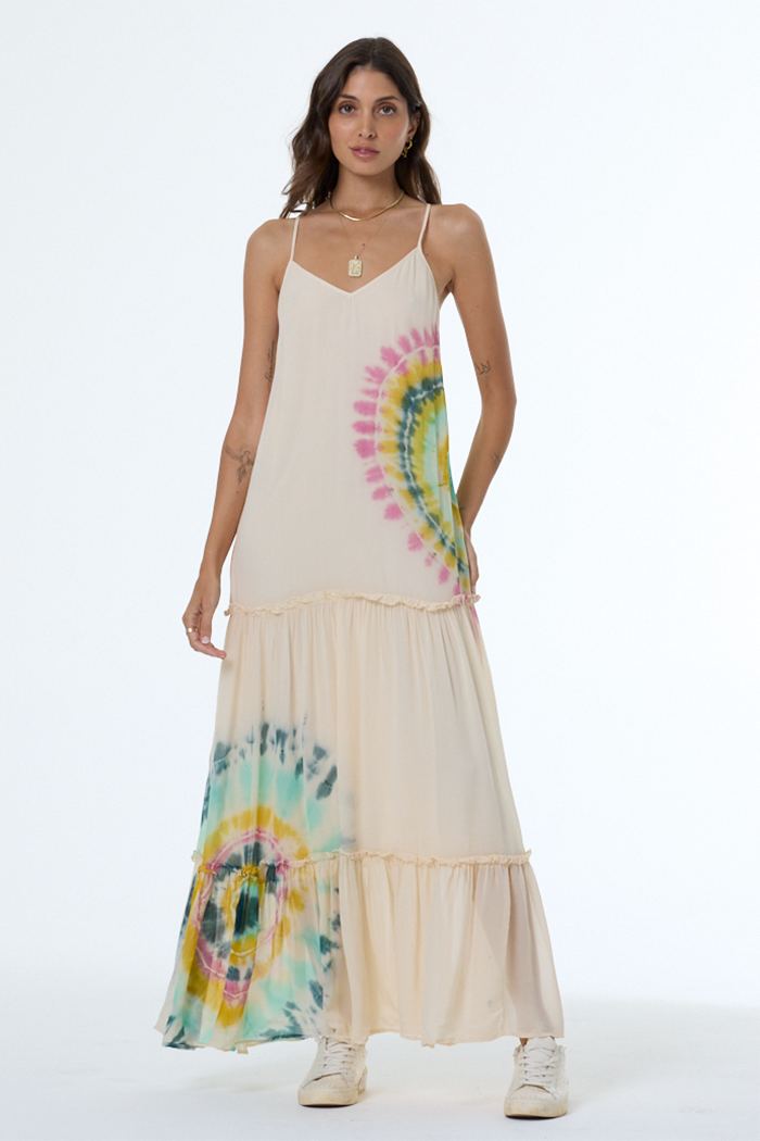 Woman wearing a long dress with tie-dye design on a white background