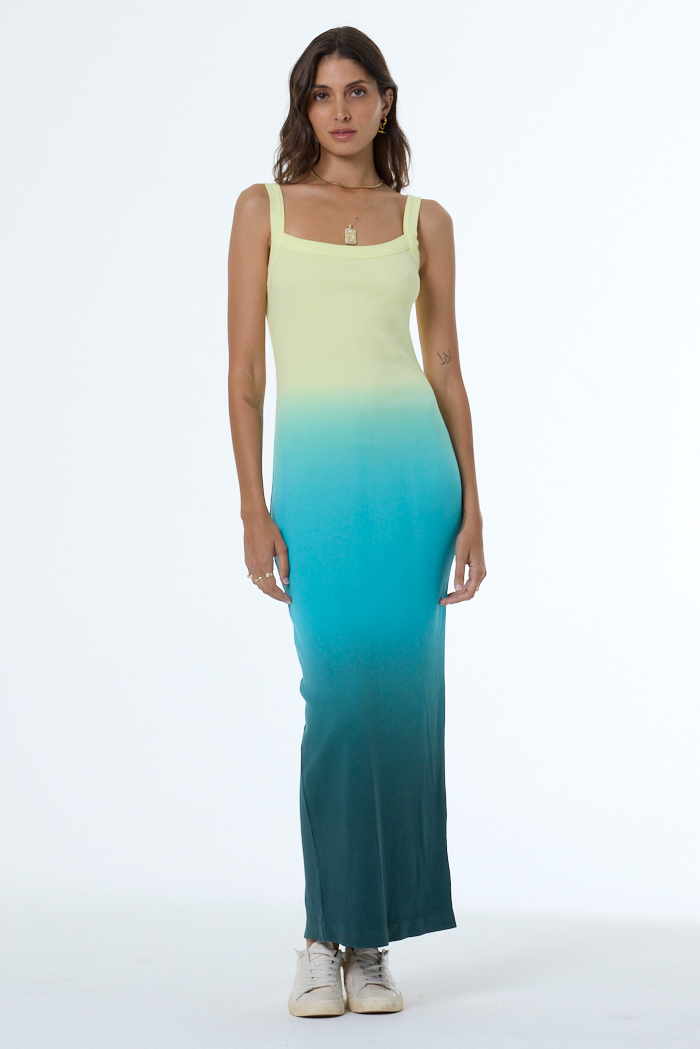 Woman wearing a gradient dress with yellow to blue color transition on a white background