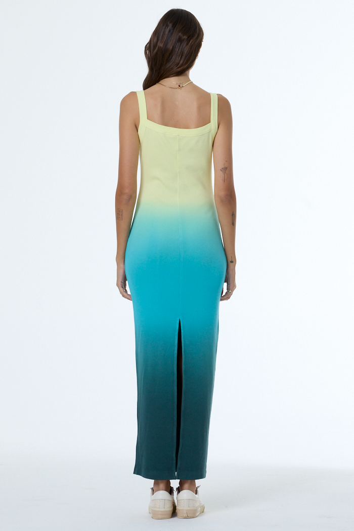 Woman wearing a gradient dress from yellow to blue on a white background