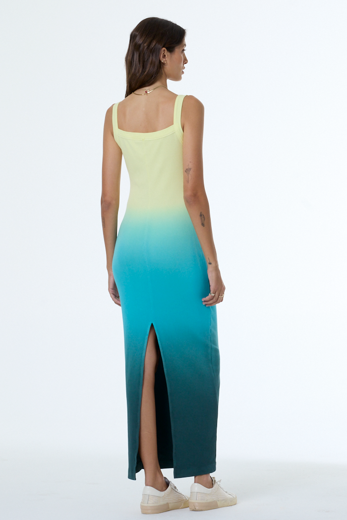 Woman wearing a gradient dress with yellow top and blue bottom on a white background