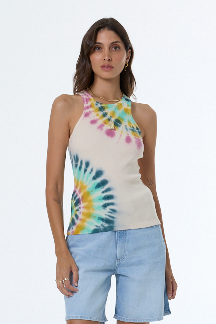 Woman wearing a tie-dye tank top and light blue shorts on a white background