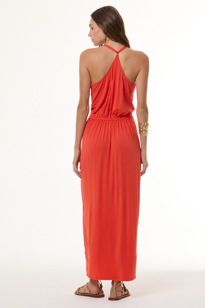 Woman wearing a deep coral dress on a white background