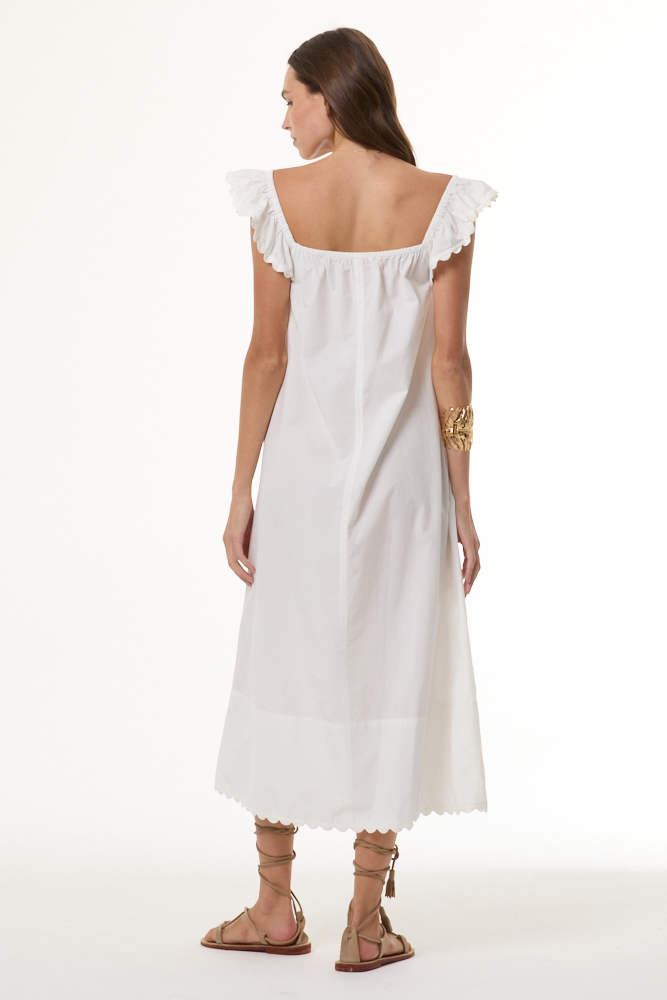 Woman wearing a white dress with ruffled sleeves on a white background