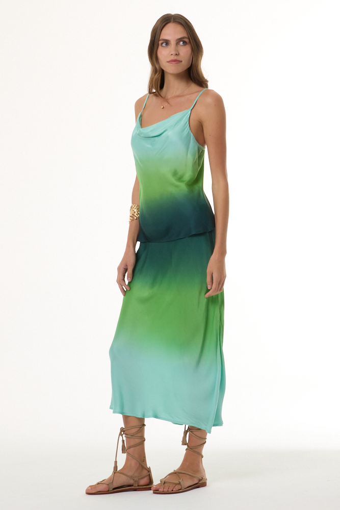 Woman wearing a green gradient tank and skirt set with a white background