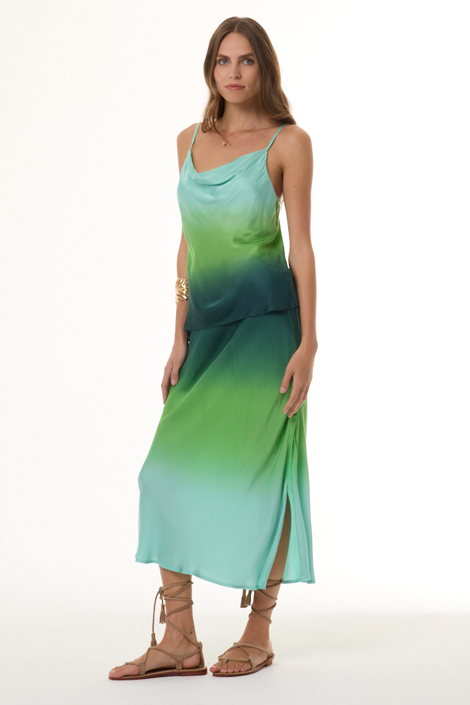 Woman wearing a gradient cami and skirt set with green and blue colors on a white background