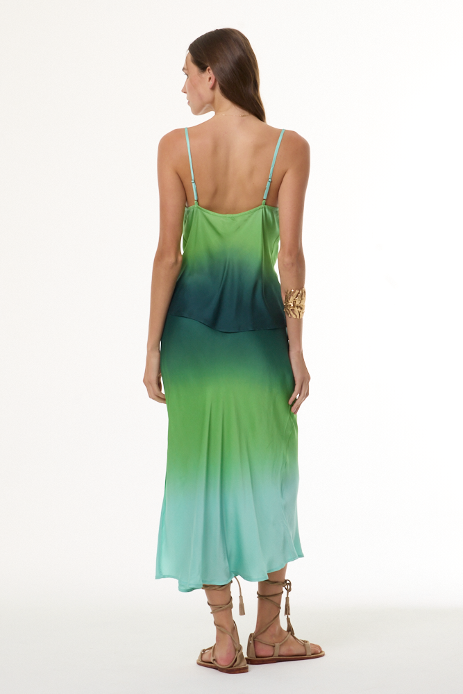 Woman wearing a gradient cami and skirt set with green and blue colors on a white background