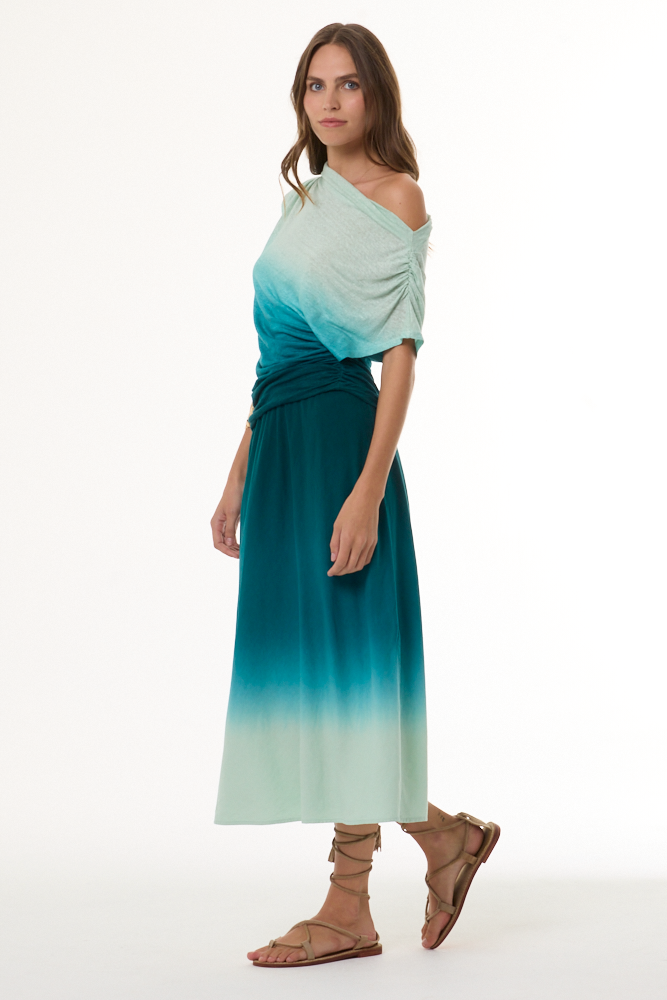 Woman wearing a gradient dress with off-shoulder top and long skirt on a white background