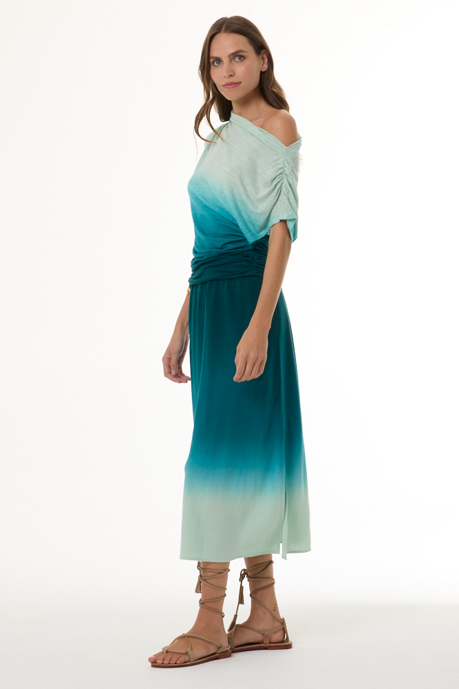 Woman wearing a gradient dress with off-shoulder top and long skirt on a white background