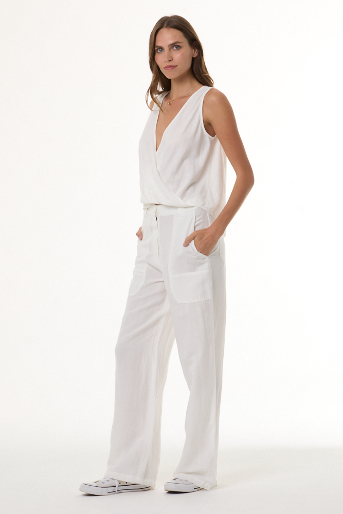 Woman wearing a white sleeveless top and pants on a white background