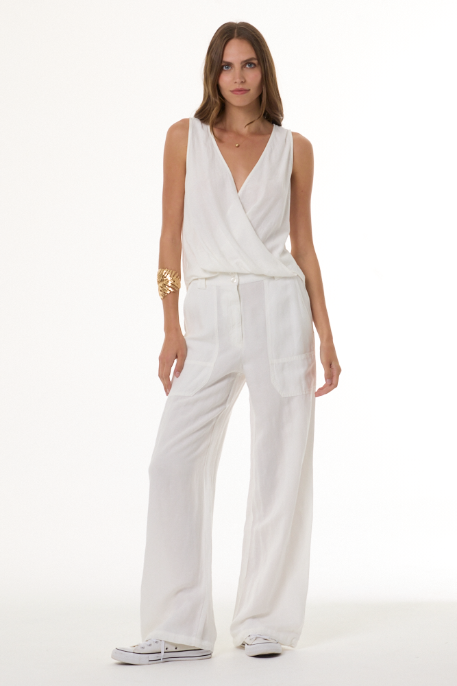 Woman wearing a white top and pant set on a white background