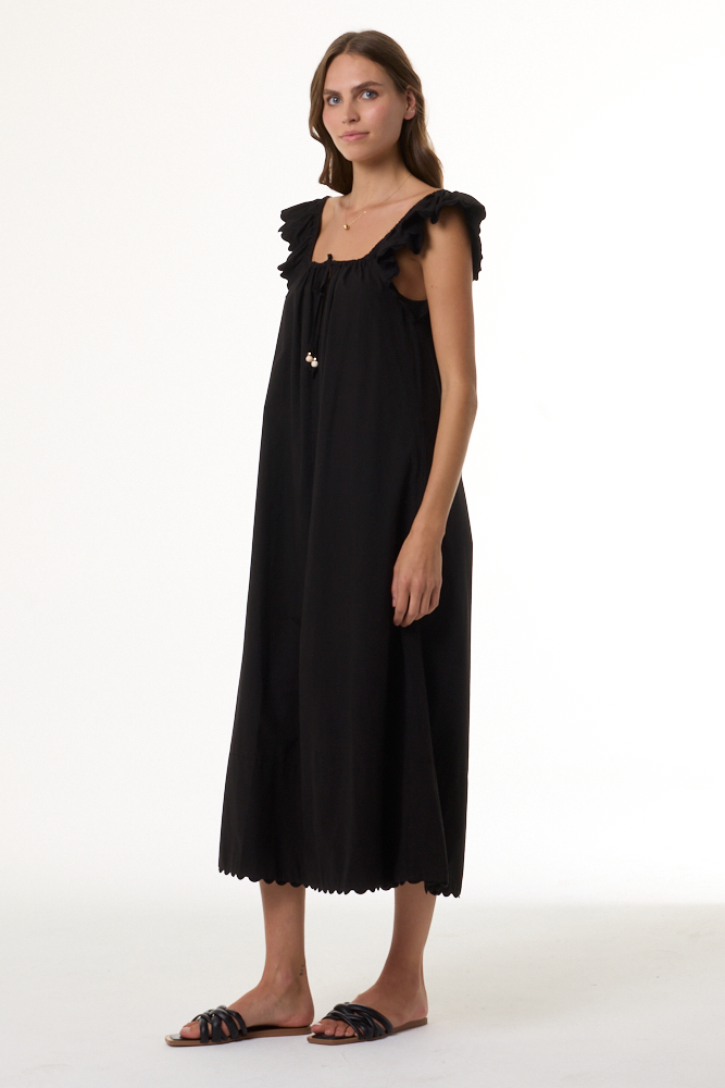 Woman wearing a black dress with ruffled shoulders on a white background
