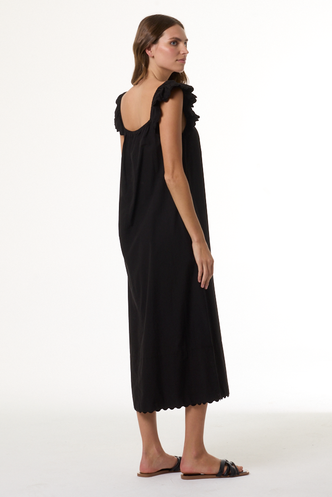 Woman wearing a black dress with ruffled shoulders on a white background