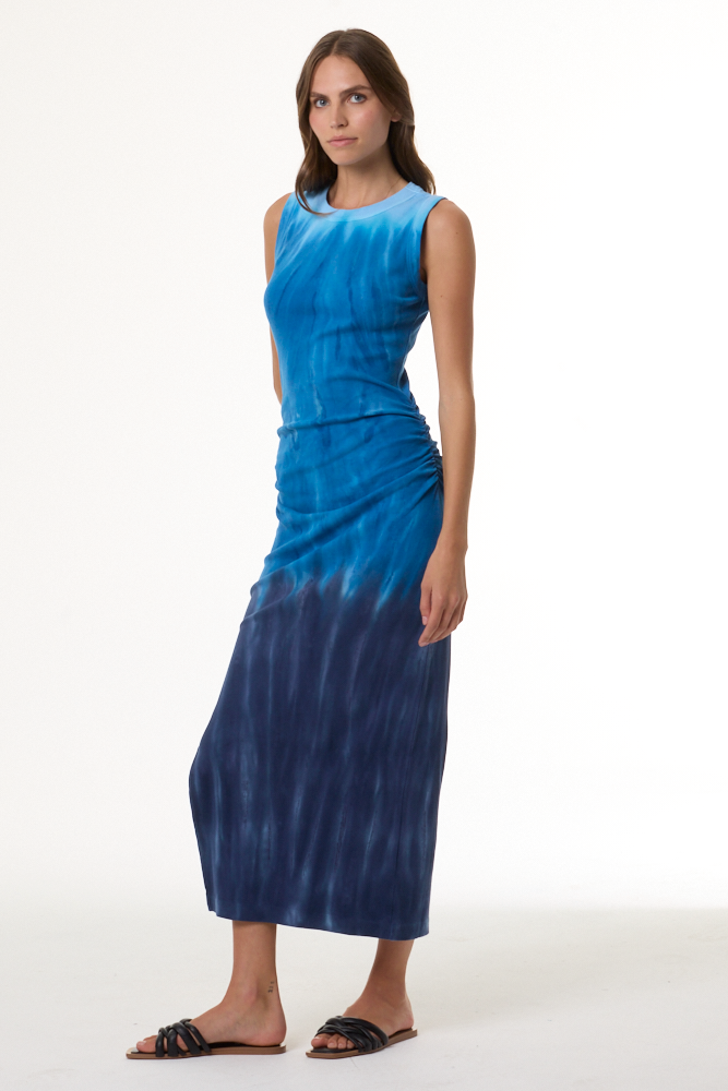 Woman wearing a blue tie-dye dress on a white background