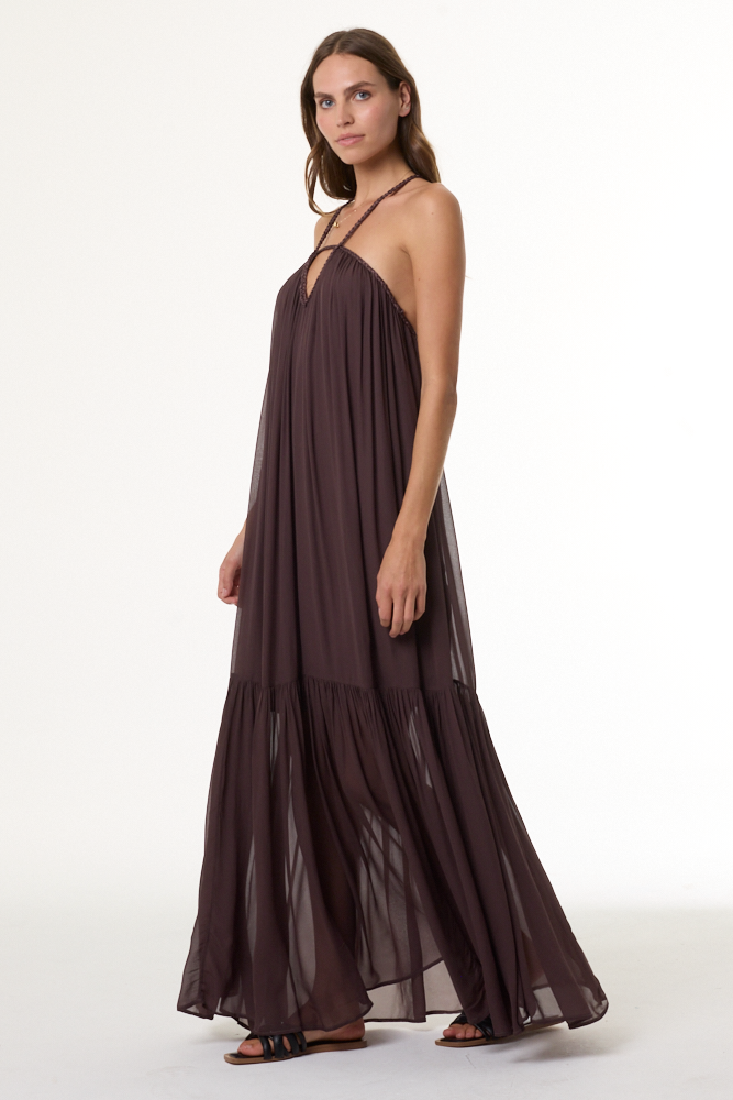 Woman wearing a long brown dress on a white background