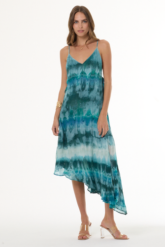 Woman wearing turquoise a tie-dye dress on a white background