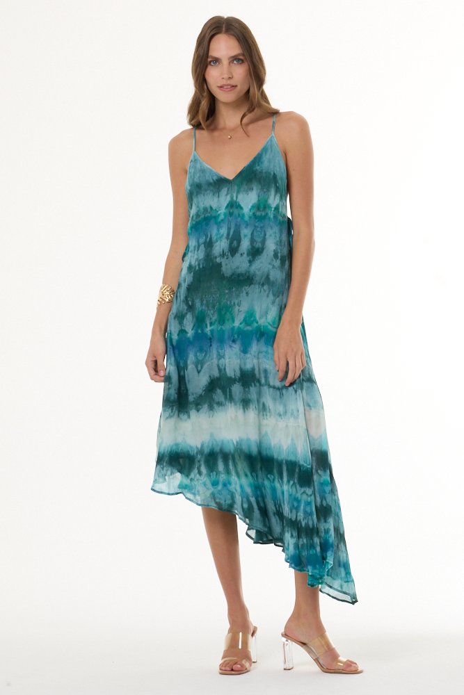 Woman wearing turquoise a tie-dye dress on a white background
