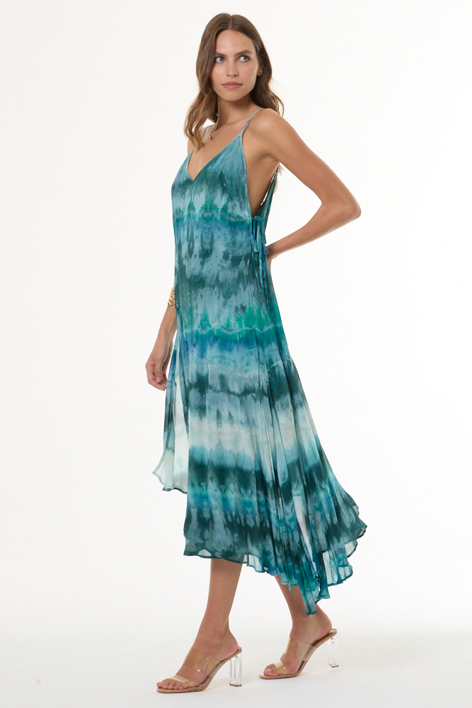 Woman wearing turquoise a tie-dye dress on a white background