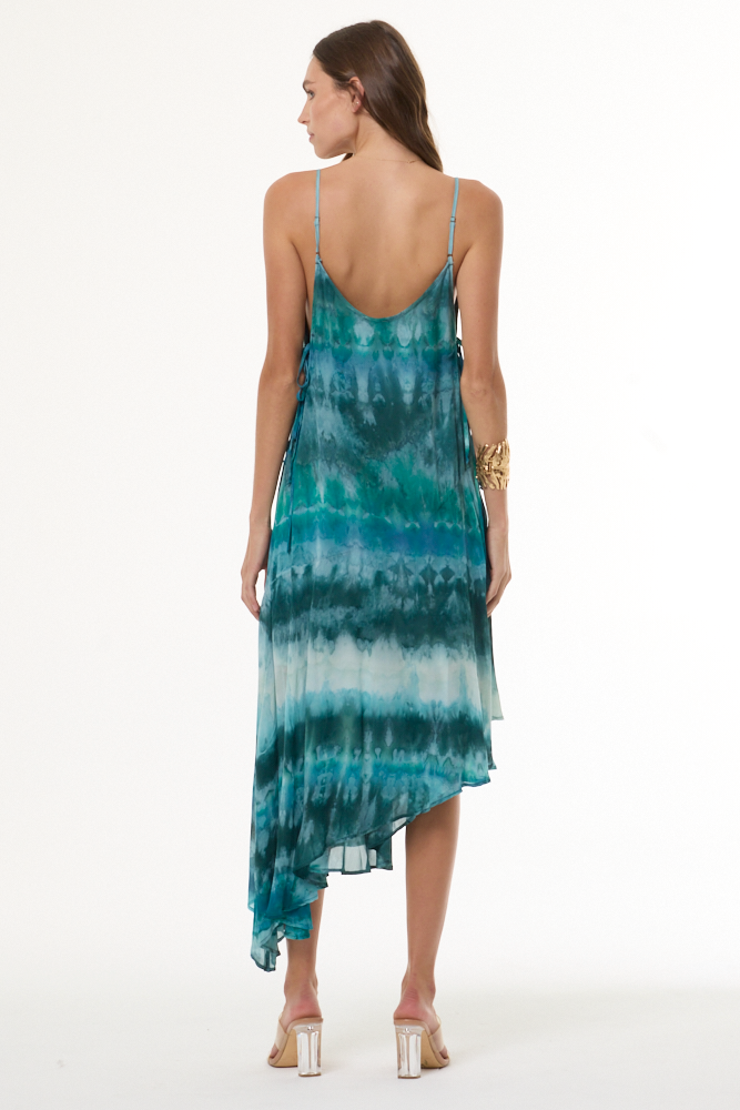 Woman wearing turquoise a tie-dye dress on a white background
