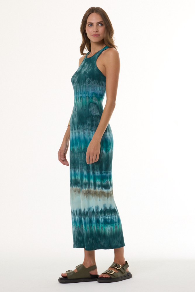 Woman wearing a turquoise tie-dye dress on a white background