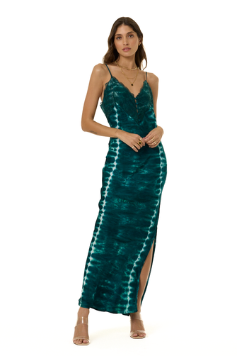 A woman modeling a long teal tie-dye maxi dress with spaghetti straps, a V-neckline, and a high side slit, photographed against a plain white background.