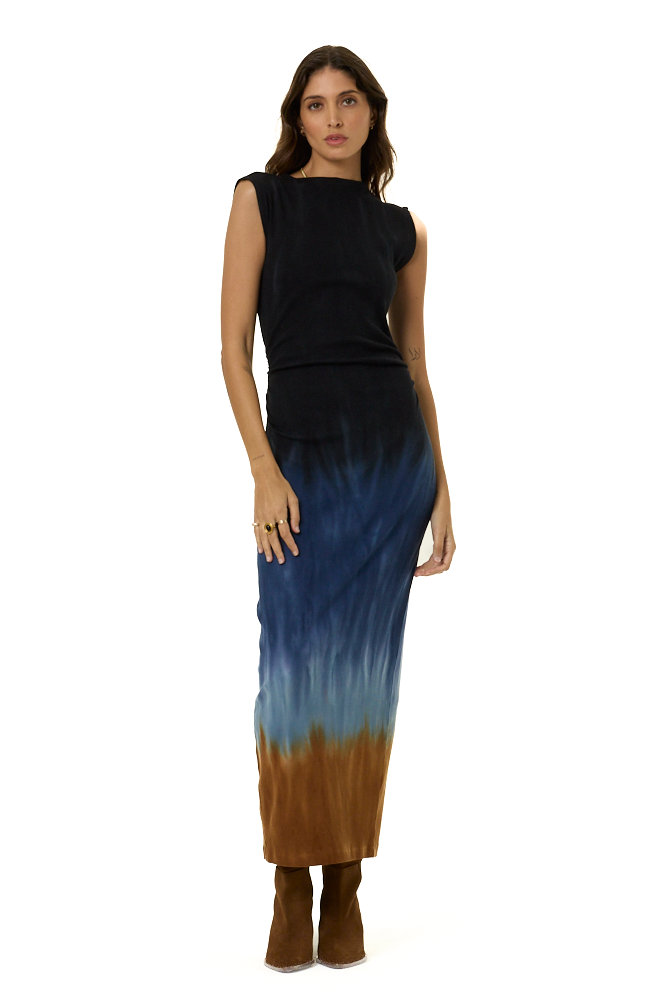 A woman modeling a sleeveless maxi dress with a black-to-blue gradient upper section and a blue-to-brown gradient lower section, paired with brown ankle boots, against a plain white background.