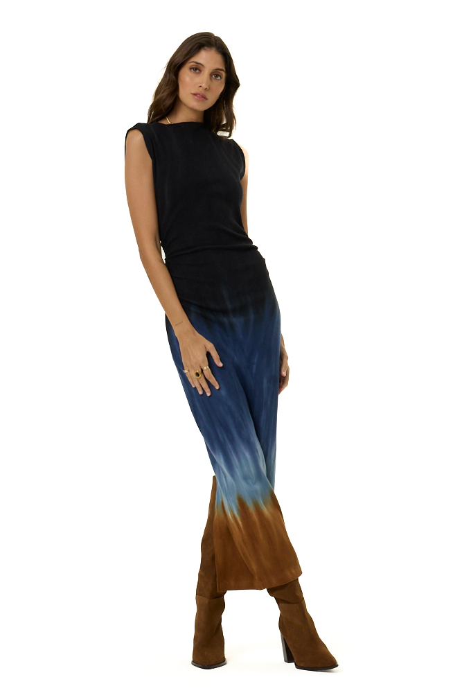 A woman modeling a sleeveless midi dress with a black-to-blue ombre upper section and a brown-to-blue ombre lower section, paired with brown ankle boots, against a plain white background.