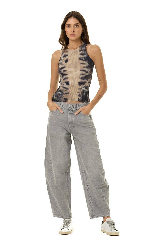 A woman modeling a sleeveless halter top with a beige and black tie-dye pattern, paired with wide-leg light gray jeans and white sneakers, against a solid white background.