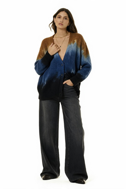 A woman modeling a cardigan with a brown-to-blue gradient tie-dye pattern, paired with wide-leg dark gray pants, against a solid white background.