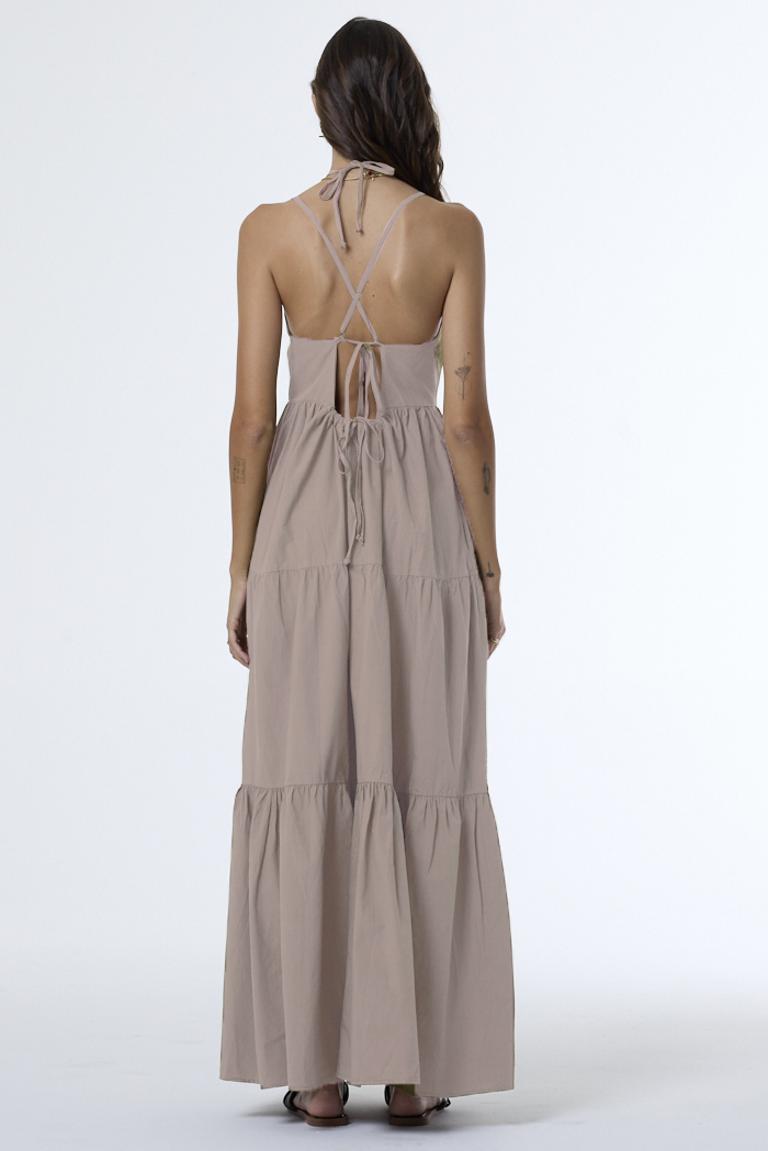Woman wearing a beige maxi dress with a white background