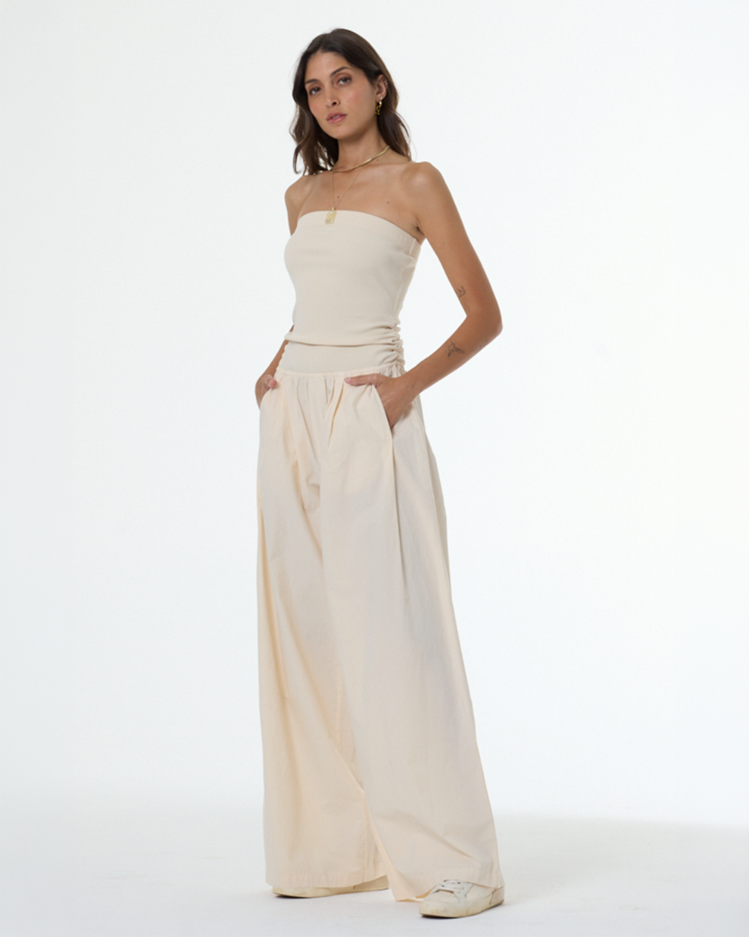 ADA compliant: Shop the Jumpsuit collection. Woman wearing a cream strapless jumpsuit.