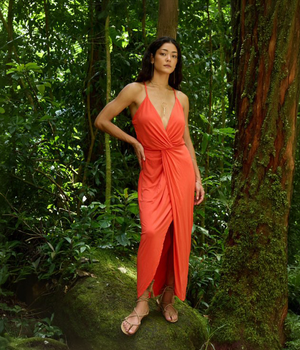 ADA Compliant: Shop the Endless Summer collection.  Woman in a red orange dress standing in a lush green forest